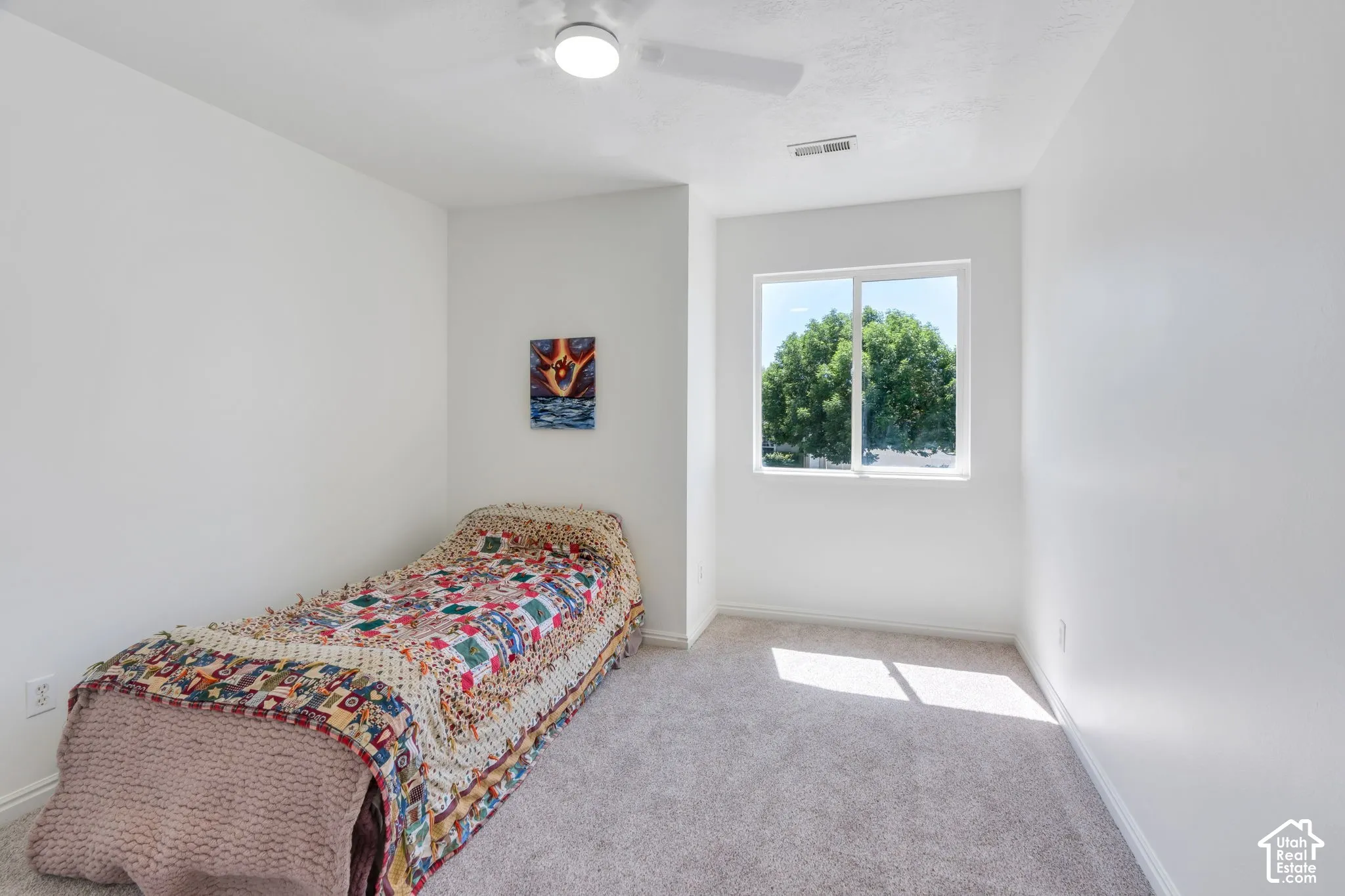 Light-filled room featuring a double-pane window, neutral carpet flooring, white walls, a ceiling fan, and white trim