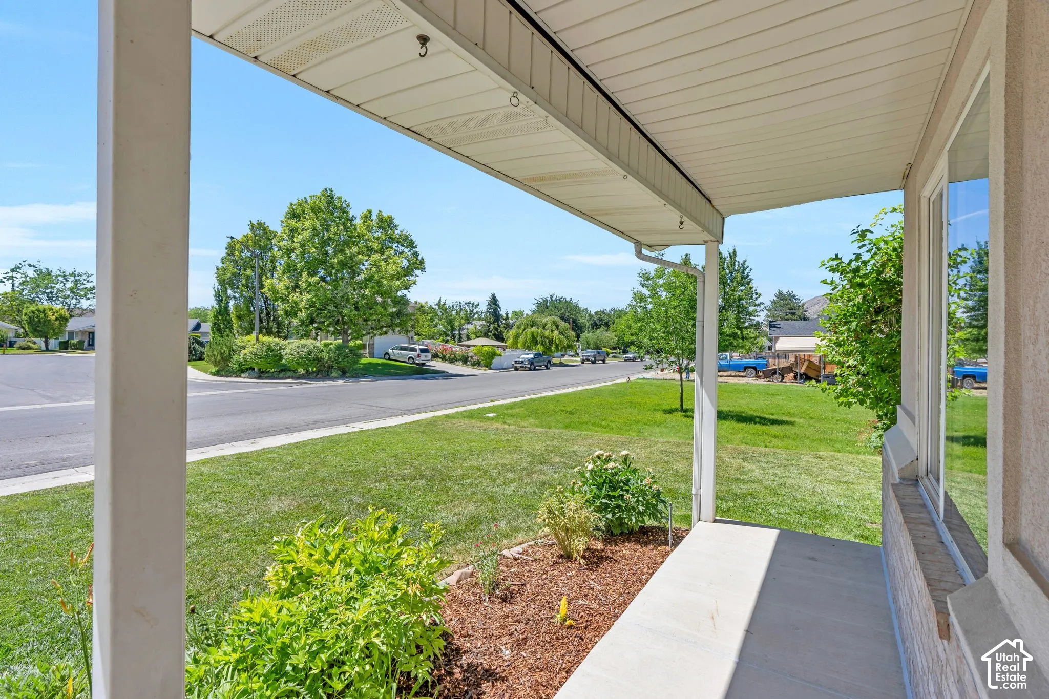 Covered front porch with concrete flooring and a textured exterior wall