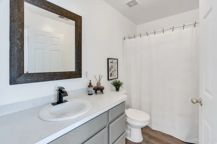 Bathroom featuring a single vanity with a white countertop, an oval undermount sink, and a matte black faucet