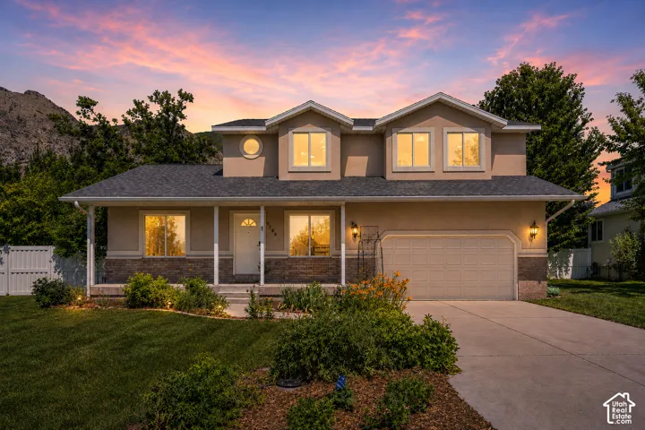 Two-story residence featuring a two-car garage, front porch with columns, a stone fa