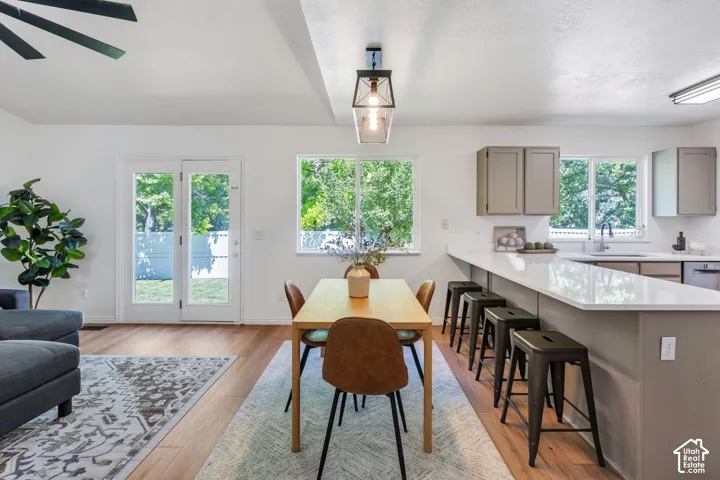 Open-concept living space featuring wood-finish flooring, white walls, and abundant natural light from multiple windows and glass-paneled French doors