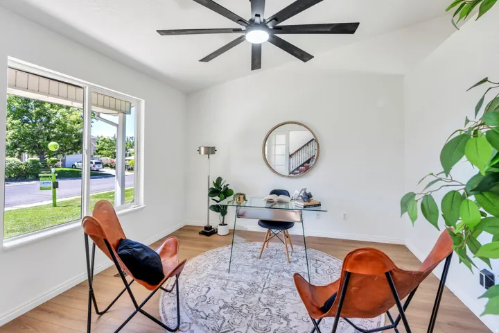 Bright interior space featuring a vaulted ceiling with a black ceiling fan