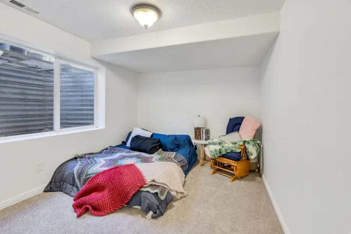 Light-filled room featuring a large egress window, neutral wall paint, and ceiling-mounted lighting