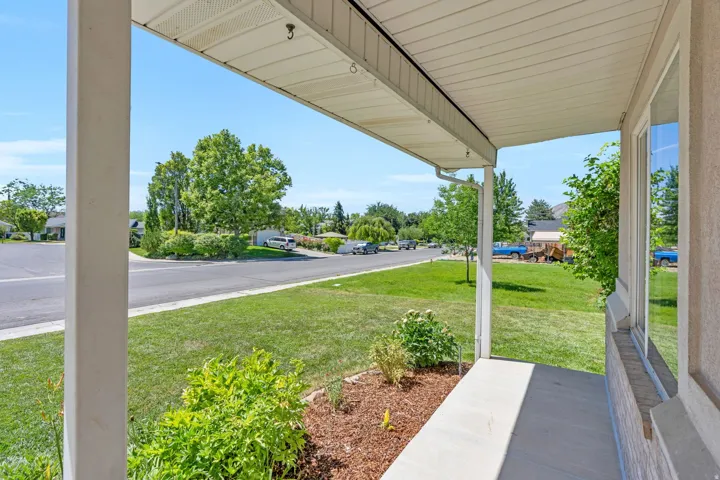 Covered front porch with concrete flooring and a textured exterior wall