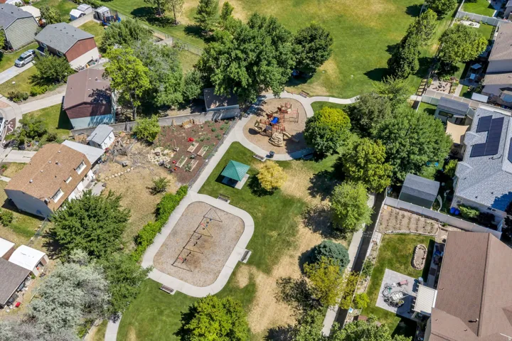 Expansive green space featuring a playground, walking paths, and mature trees