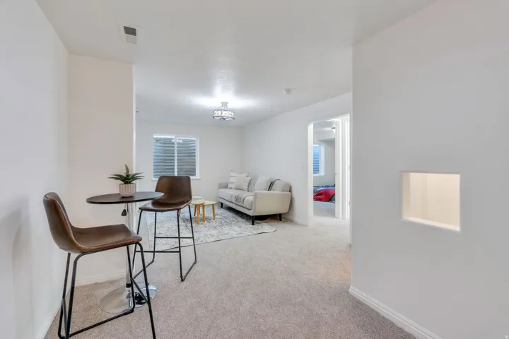 Carpeted living space featuring recessed lighting and a window with horizontal blinds