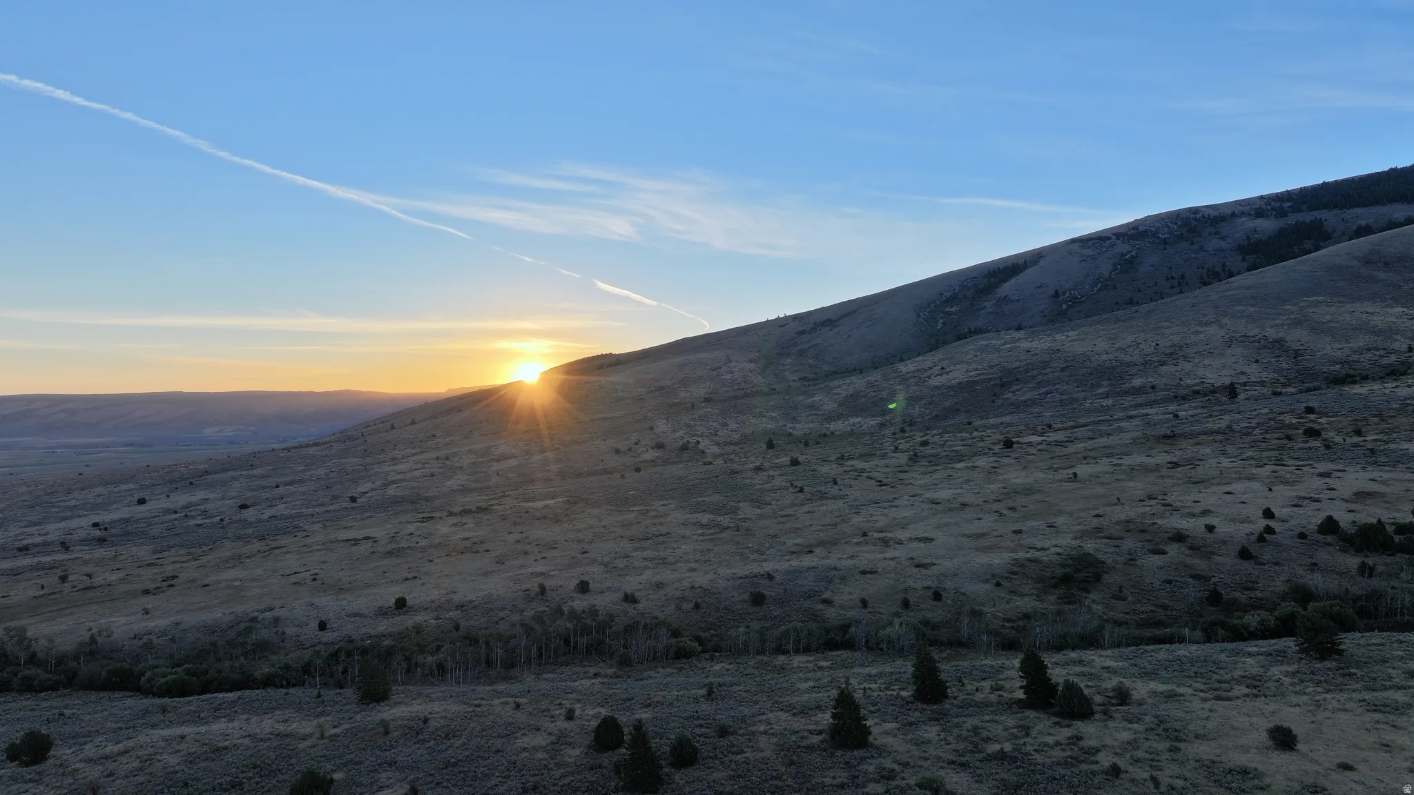 Expansive mountainous terrain with varied ground cover and distant landscape features