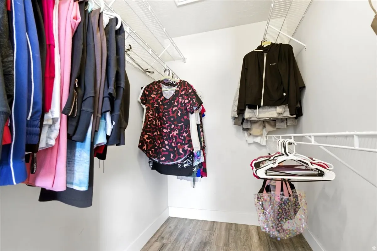 Walk-in closet featuring light wood-finish flooring and white wire shelving