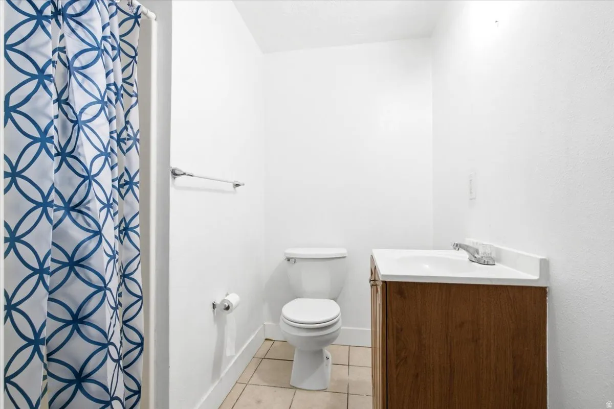 Bathroom featuring a single vanity with wood-finish cabinetry, white countertop, and integrated sink