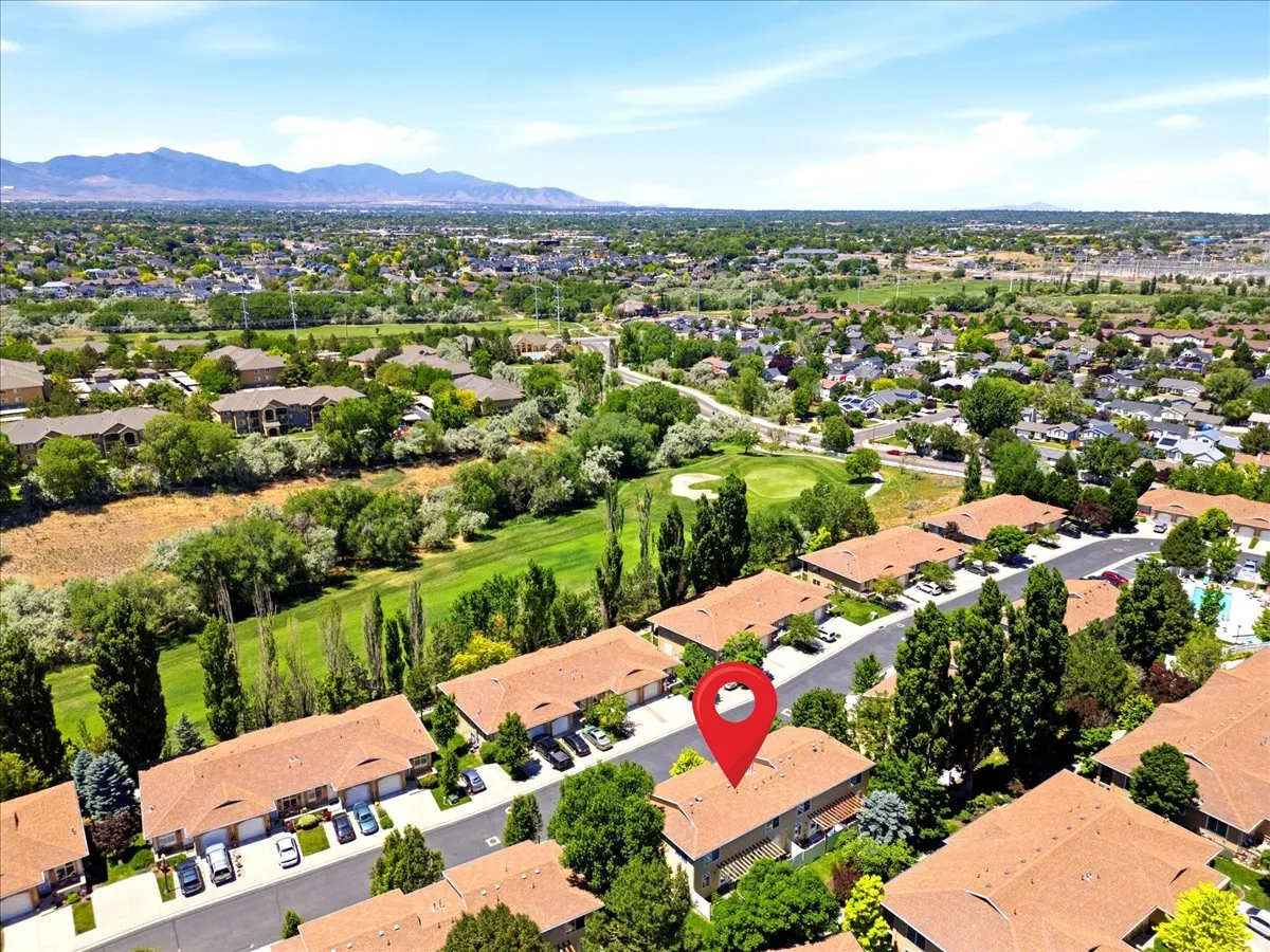 Aerial perspective showcasing a residential community with abundant mature trees and mountainous terrain