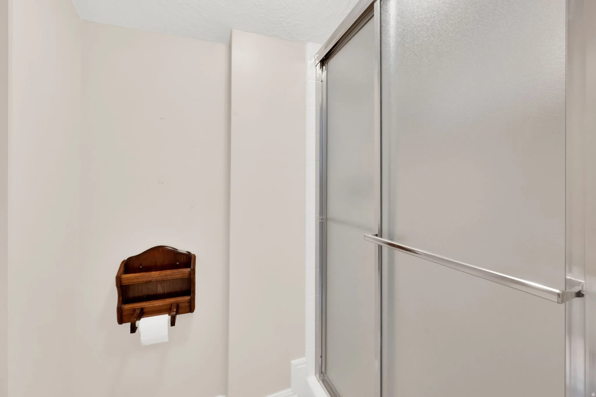 Shower enclosure with frosted glass panels and a chrome-finish towel bar