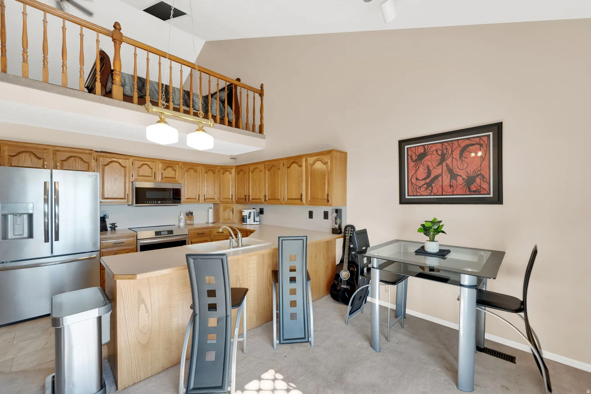 Kitchen with light wood cabinetry, stainless steel appliances, and a double basin sink