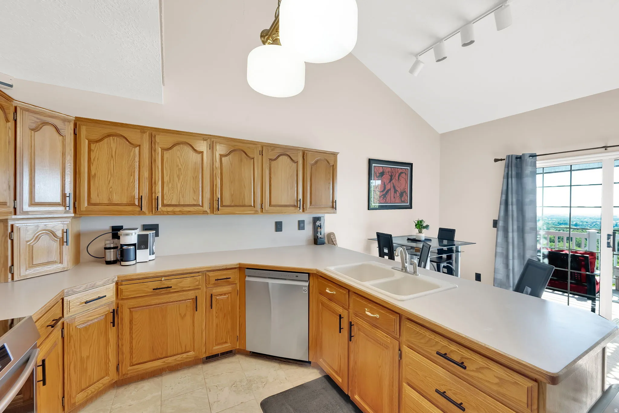 Kitchen featuring wood cabinetry, a double basin sink, and ample countertop space