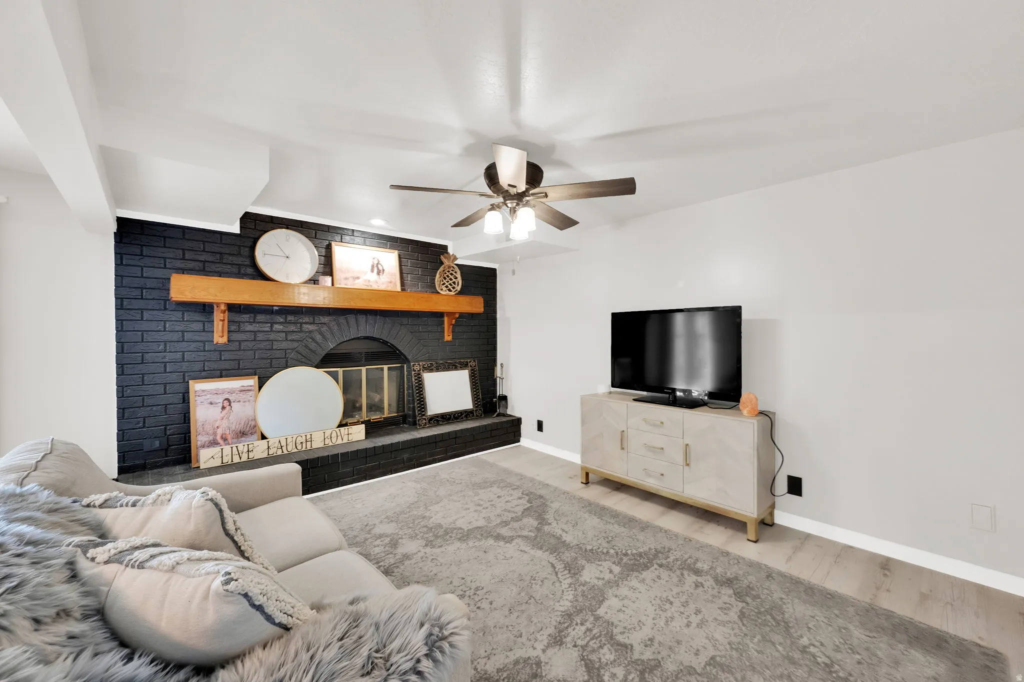 Living area featuring a black brick fireplace with an arched firebox opening and a wood mantel