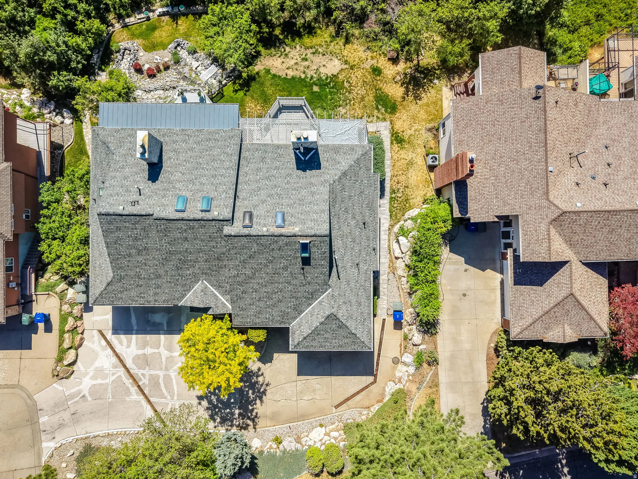 Aerial view of a sprawling residential property featuring a multi-level roofline with skylights and multiple chimneys