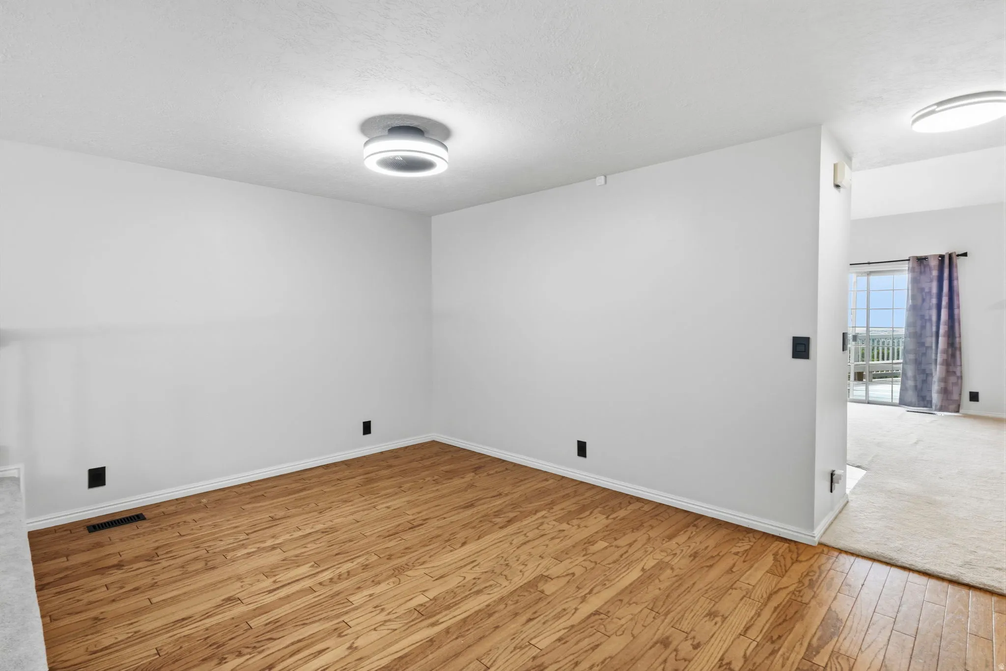 Wood-finish flooring with a modern flush-mount ceiling light