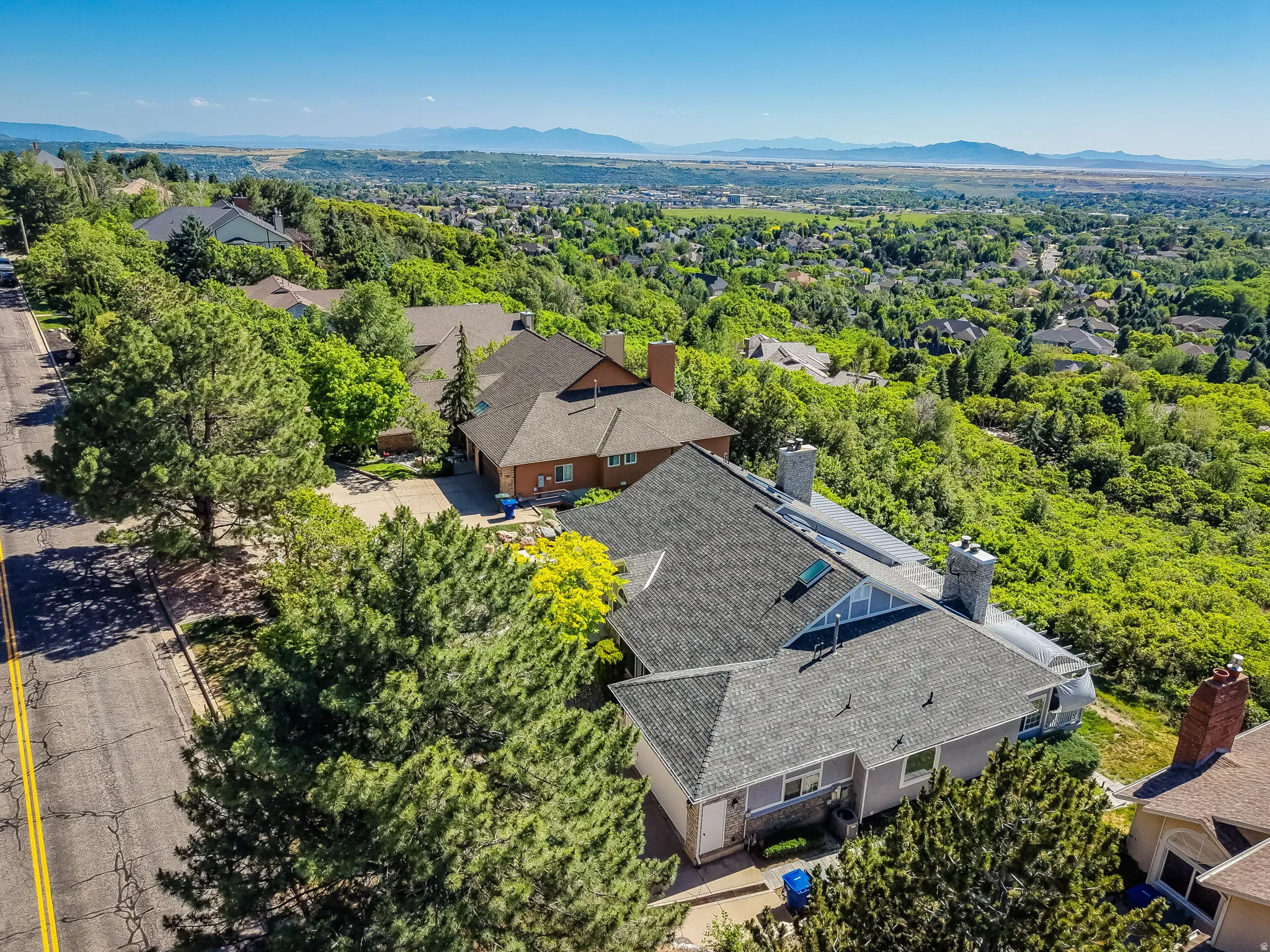 Expansive property featuring a multi-level roofline, skylights, and multiple chimneys
