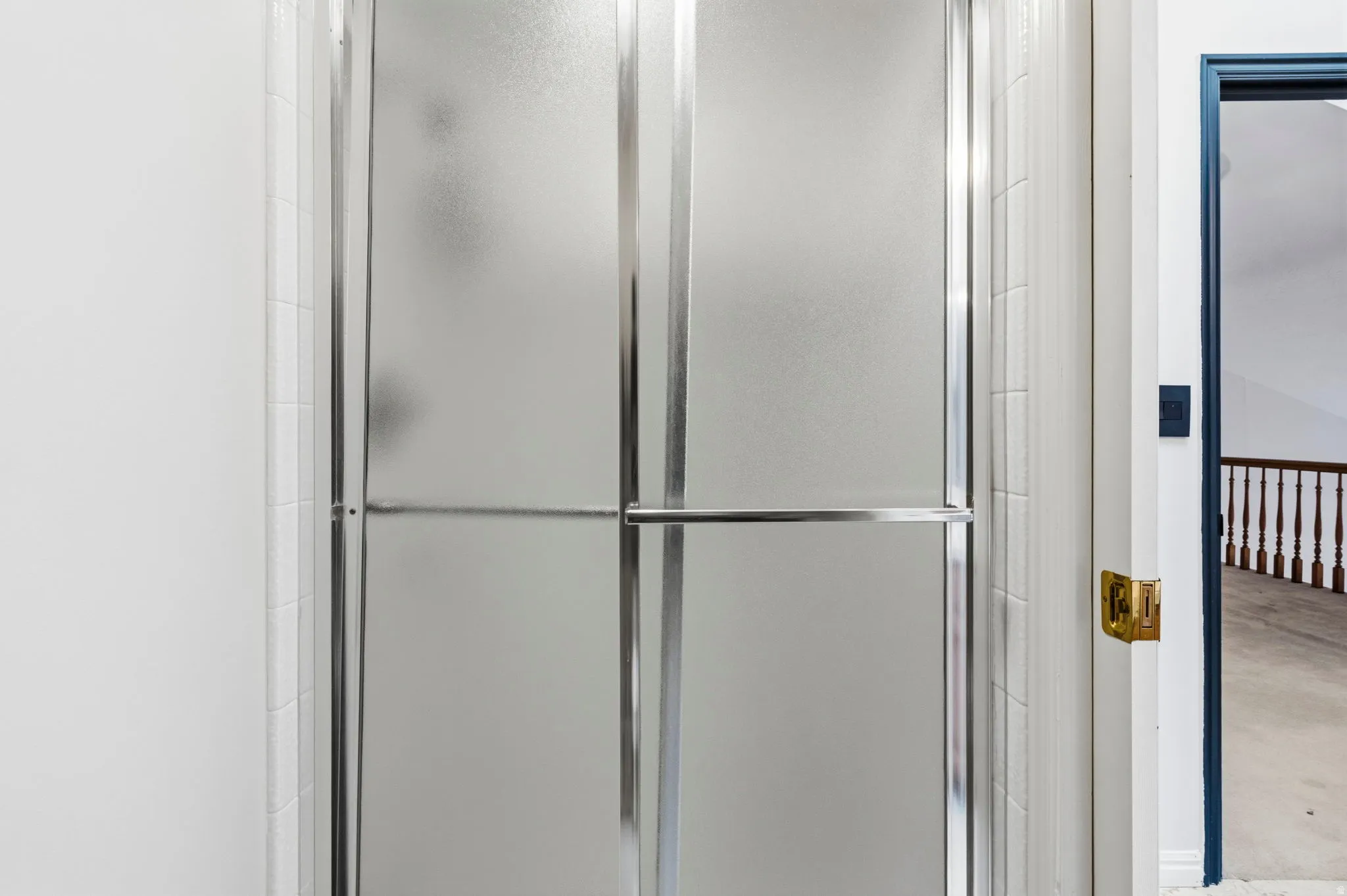 Frosted glass shower enclosure with chrome hardware