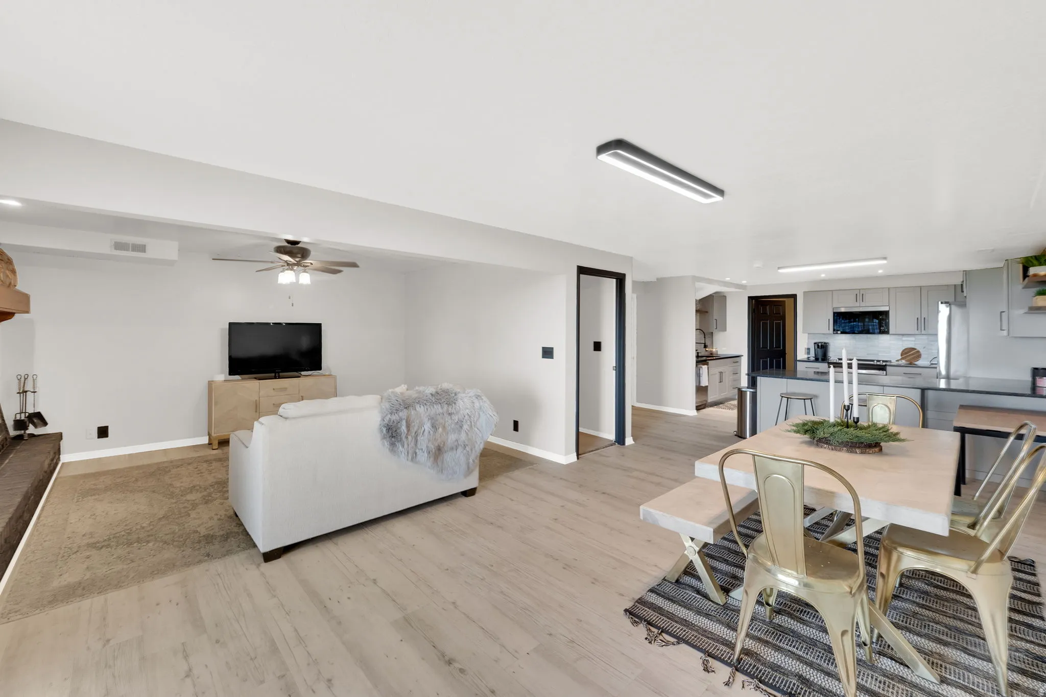 Open-concept living space featuring wood-finish flooring, a contemporary ceiling fan, and recessed lighting