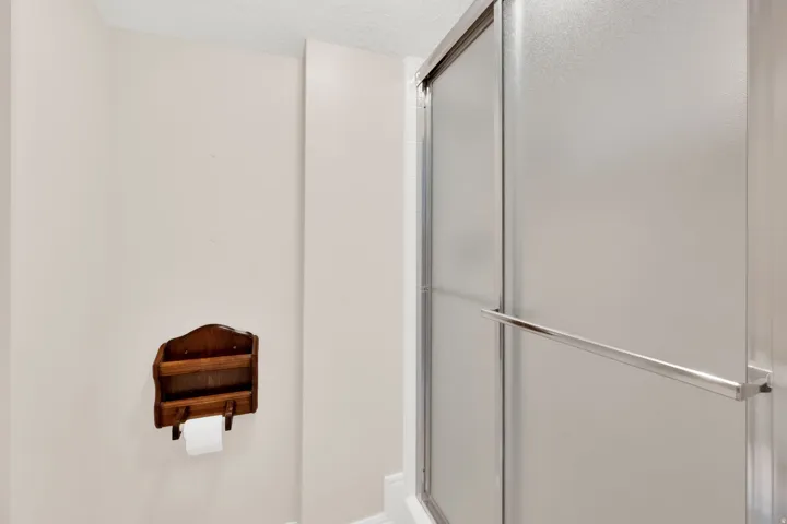 Shower enclosure with frosted glass panels and a chrome-finish towel bar