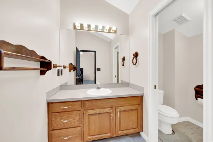 Bathroom vanity with a light wood-finish cabinet, countertop, and an integrated sink