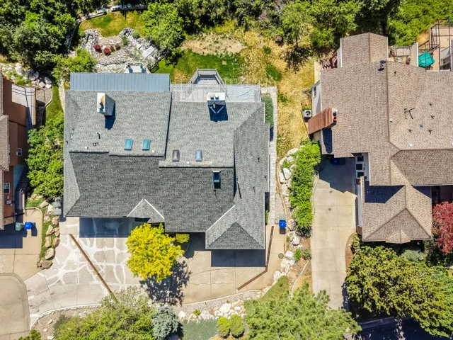 Aerial view of a sprawling residential property featuring a multi-level roofline with skylights and multiple chimneys
