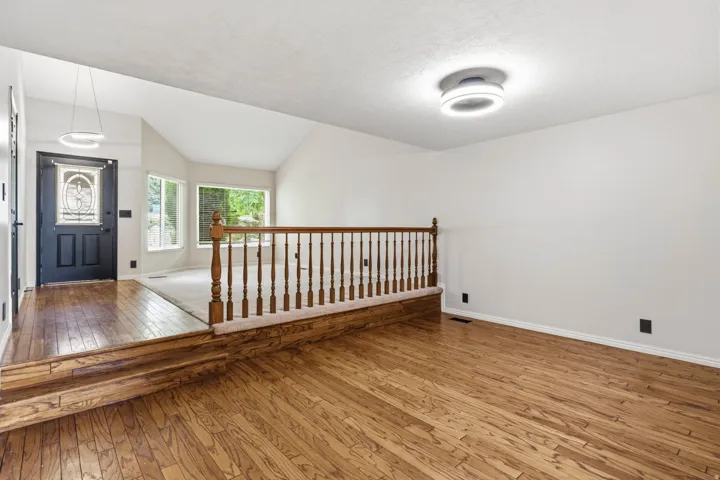 Wood-finish flooring throughout, with a decorative wood railing separating spaces