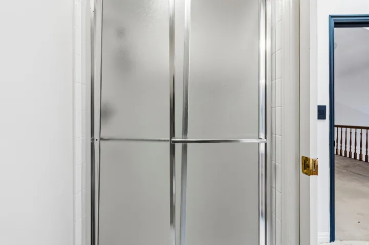 Frosted glass shower enclosure with chrome hardware