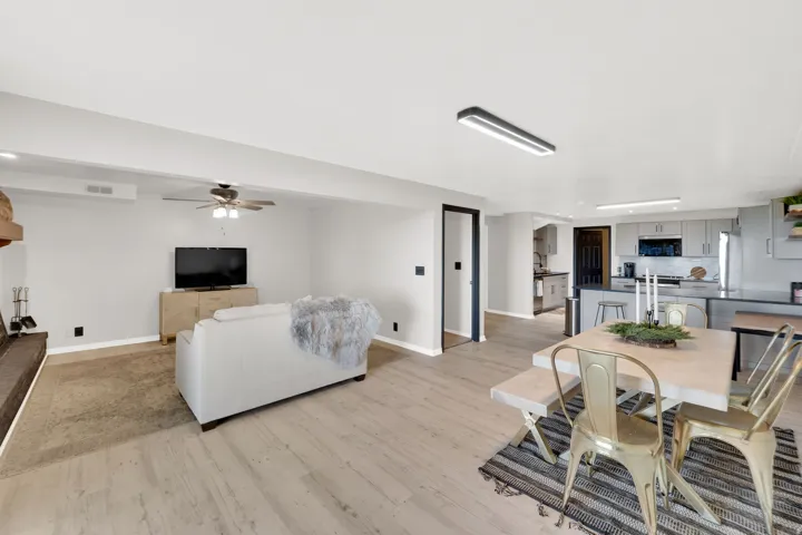 Open-concept living space featuring wood-finish flooring, a contemporary ceiling fan, and recessed lighting