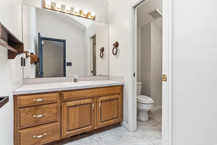 Wood-finish vanity with a white countertop and integrated sink