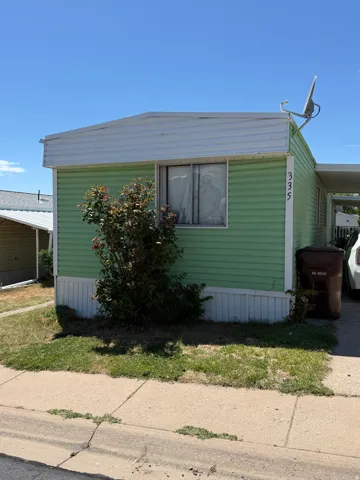 Light green siding exterior with white trim and a covered carport