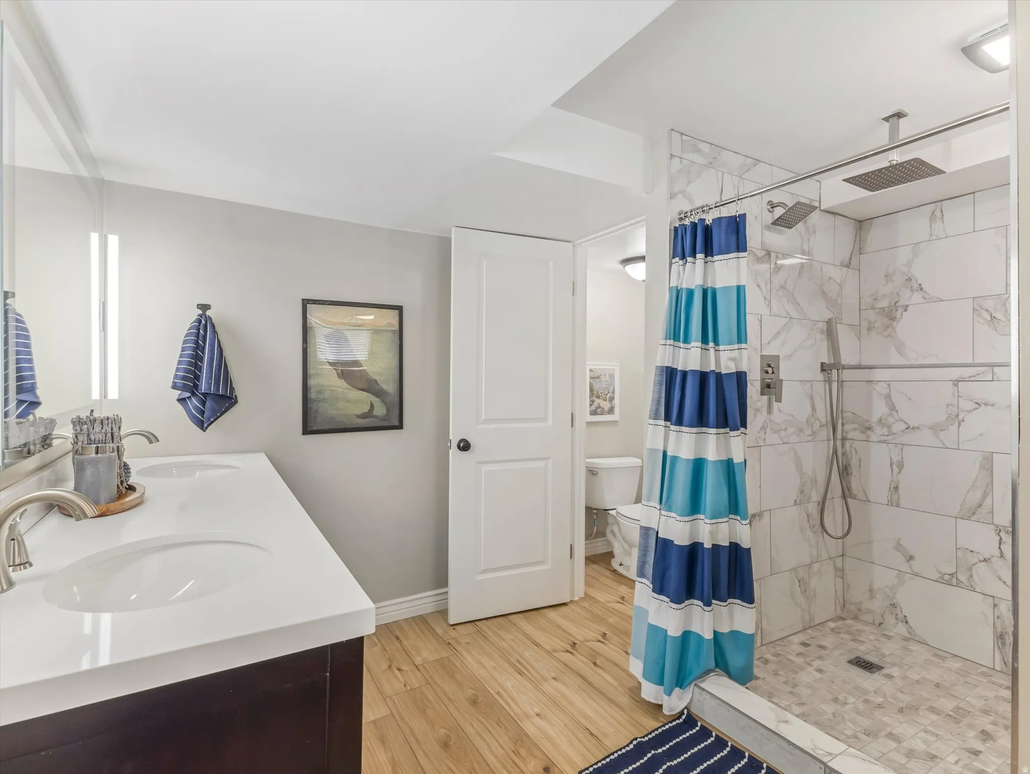 PRIMARY Bathroom featuring a dual vanity with undermount sinks, quartz countertops, and brushed nickel fixtures