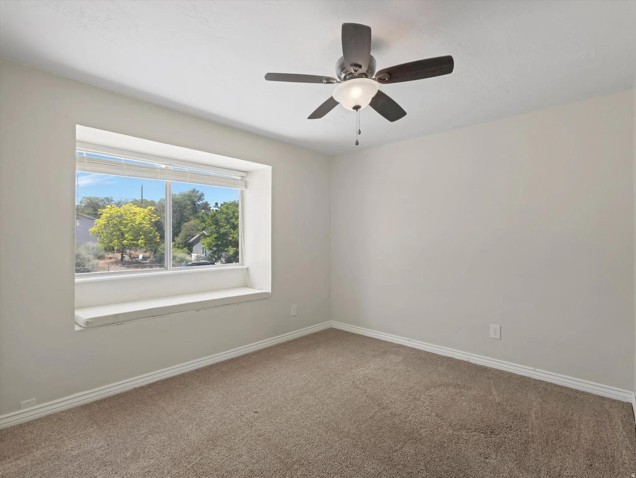 Room featuring a recessed window with a built-in window seat, neutral wall paint, and plush carpet flooring