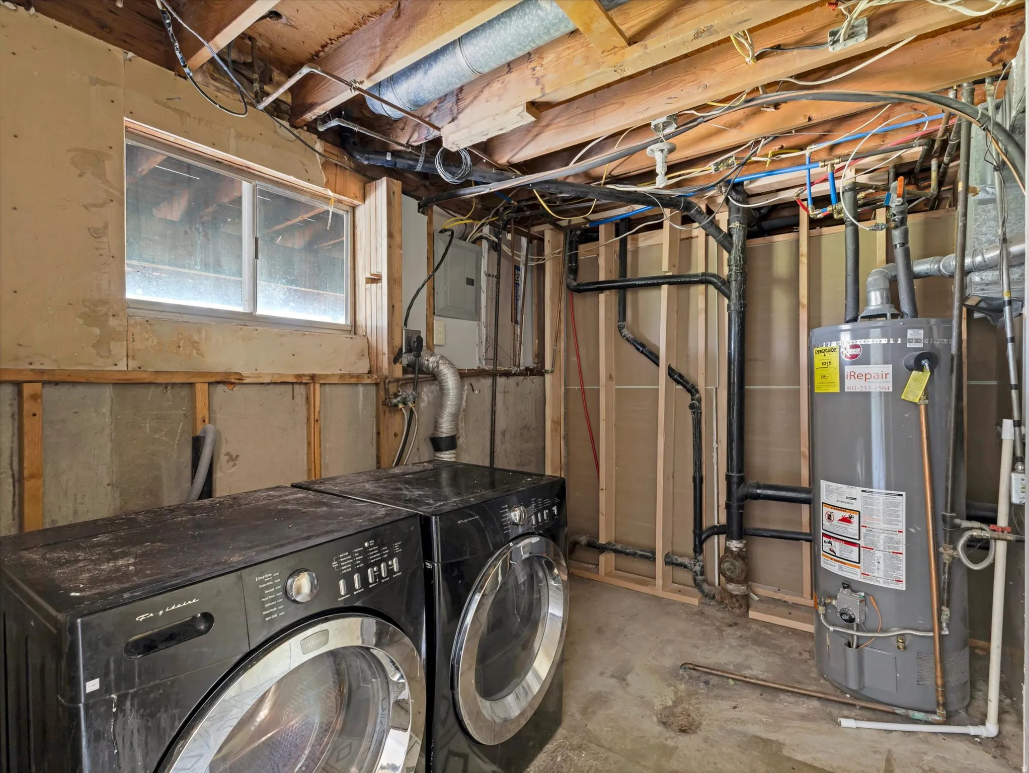 Utility space with water heater, exposed wood joists, visible plumbing, and concrete flooring