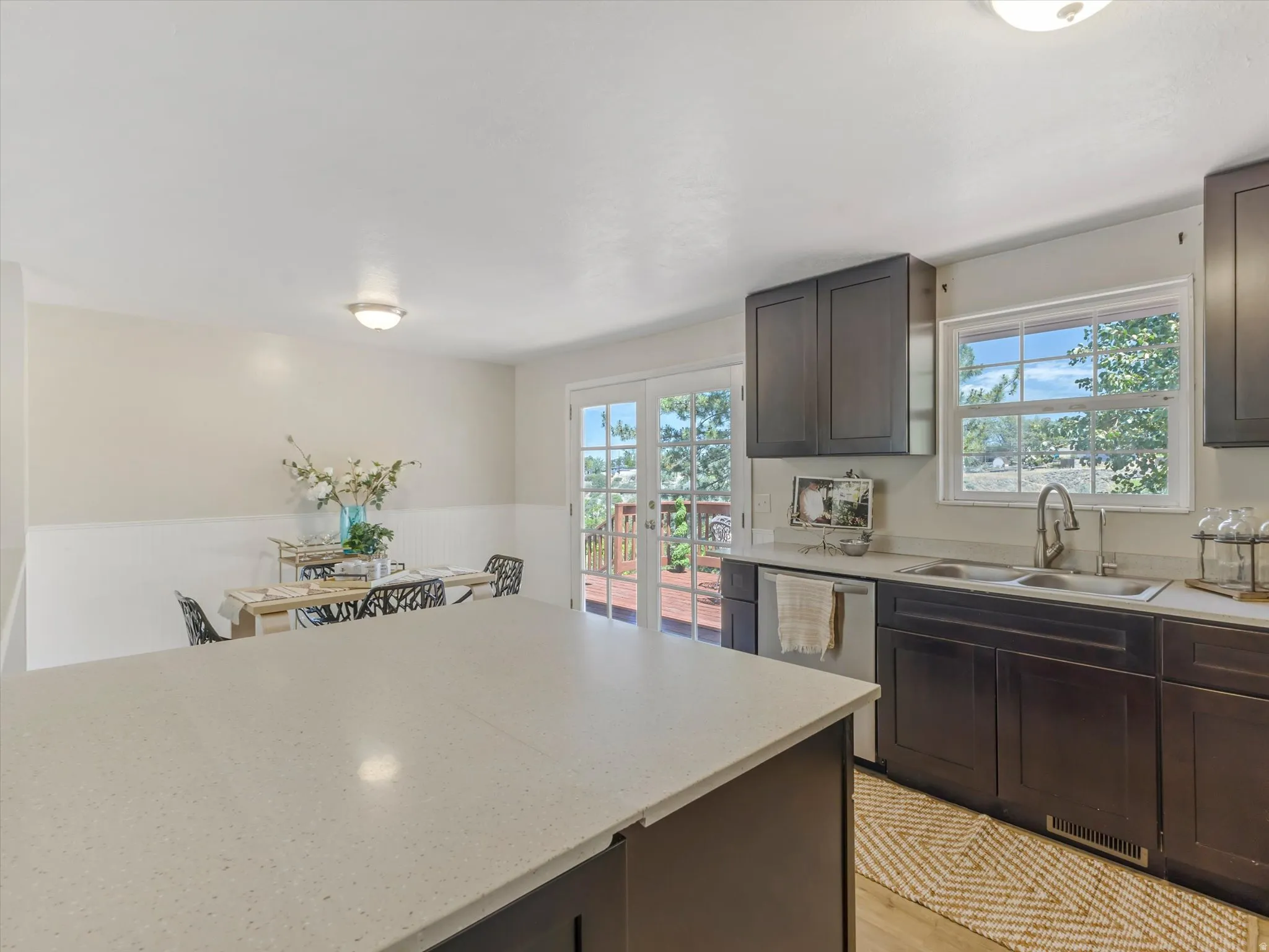 Kitchen featuring a large light-toned countertop, dark cabinetry, and stainless steel appliances
