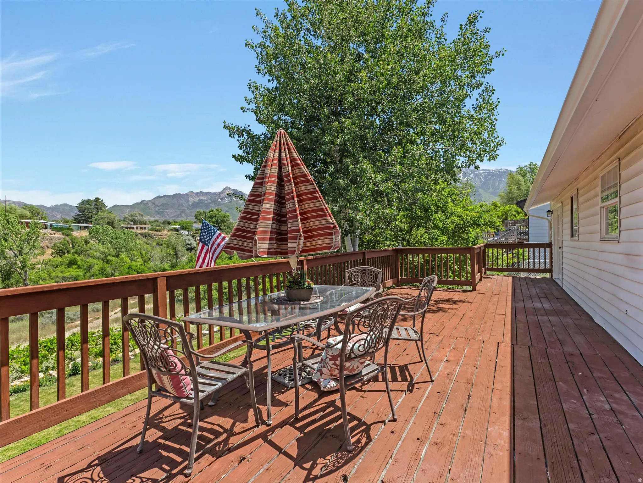 Spacious wood-finish deck with railing and distant mountain scenery