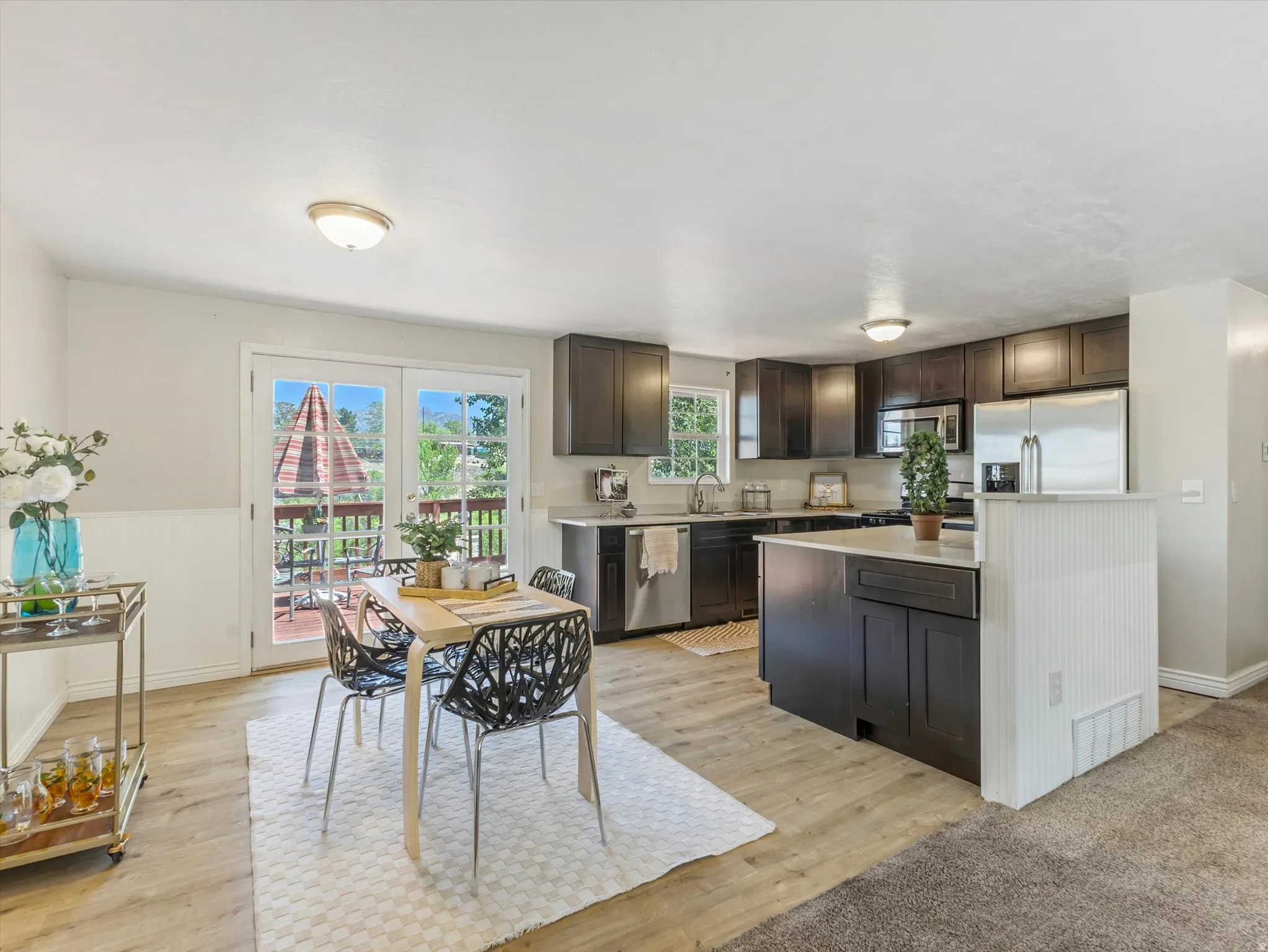 Eat-in kitchen featuring dark wood cabinetry, stainless steel appliances, and light countertops