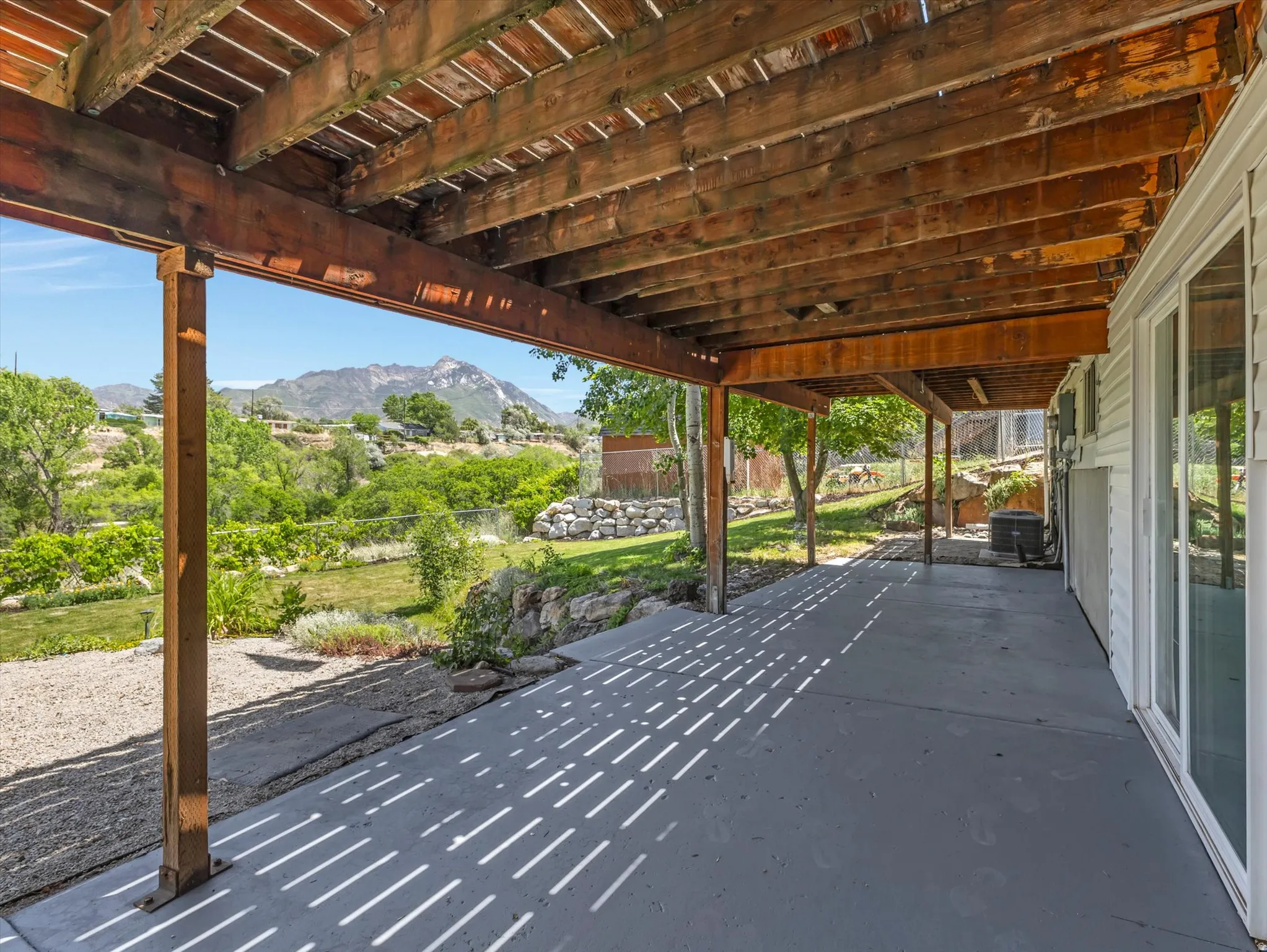 Covered concrete patio with exposed wood joists and support beams
