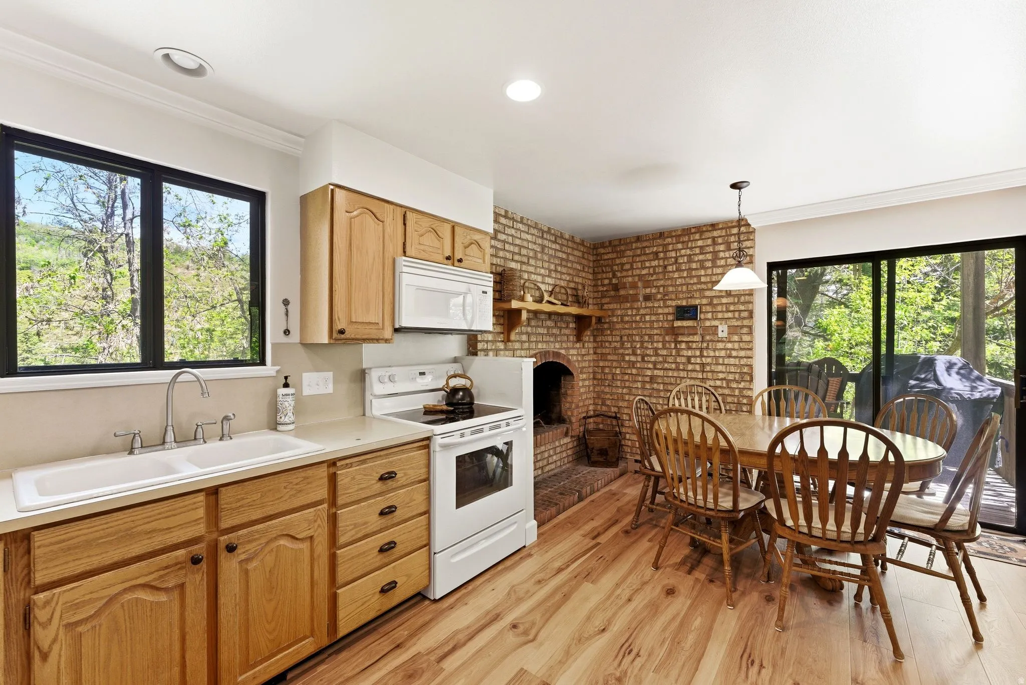 Kitchen with wood-finish flooring, light wood cabinetry, and a double basin sink