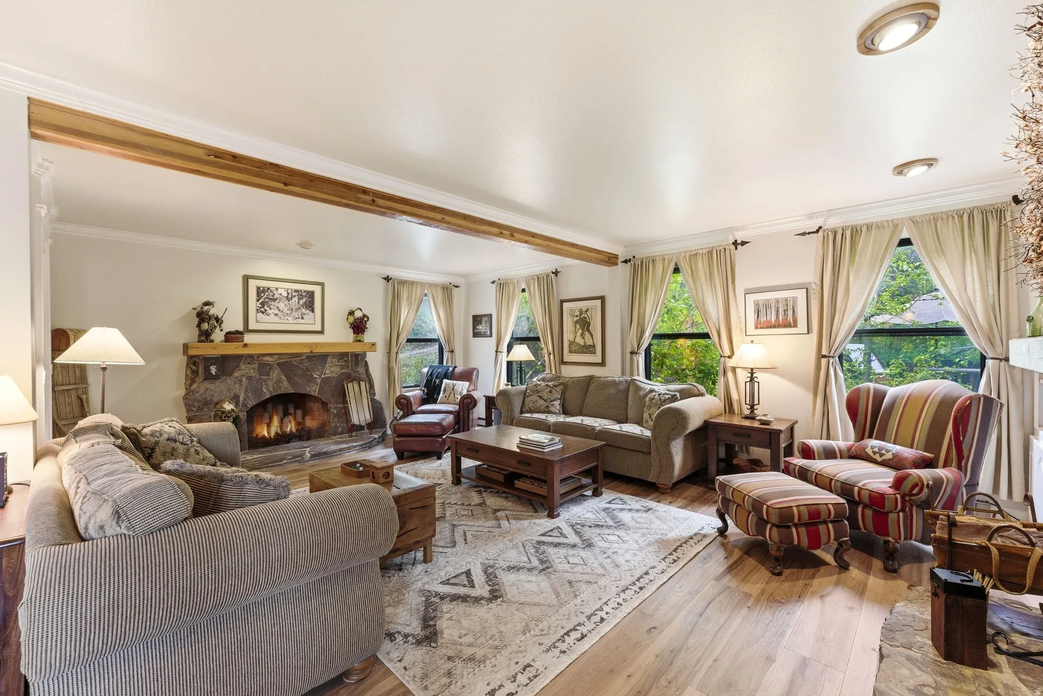 Living area with wood-finish flooring and a stone-clad fireplace