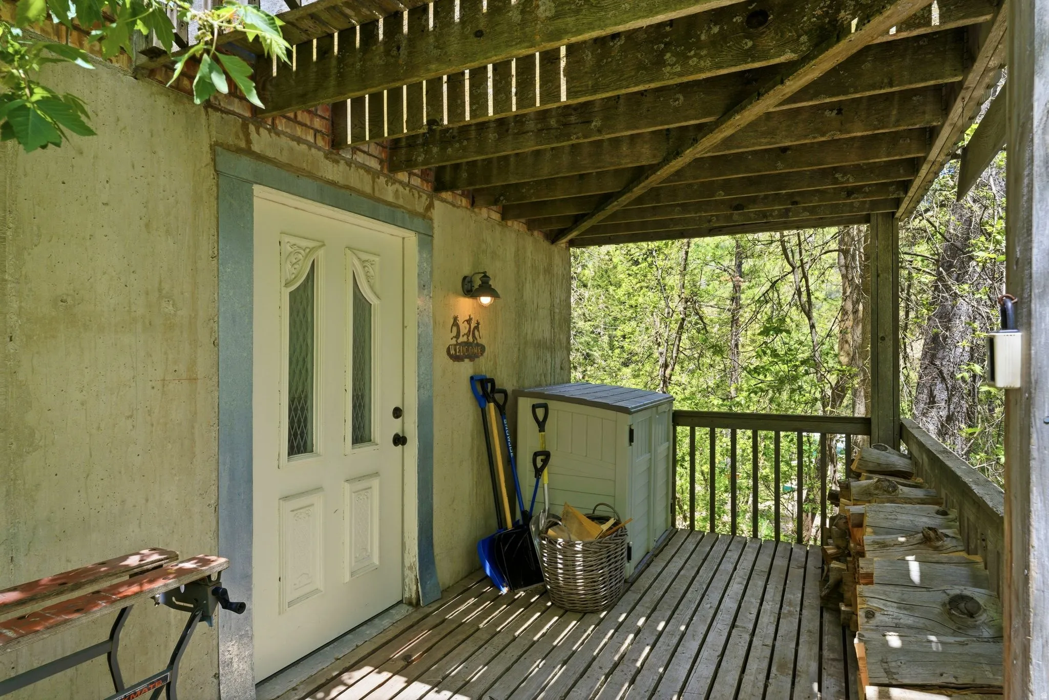 Covered outdoor deck featuring natural wood flooring and railing
