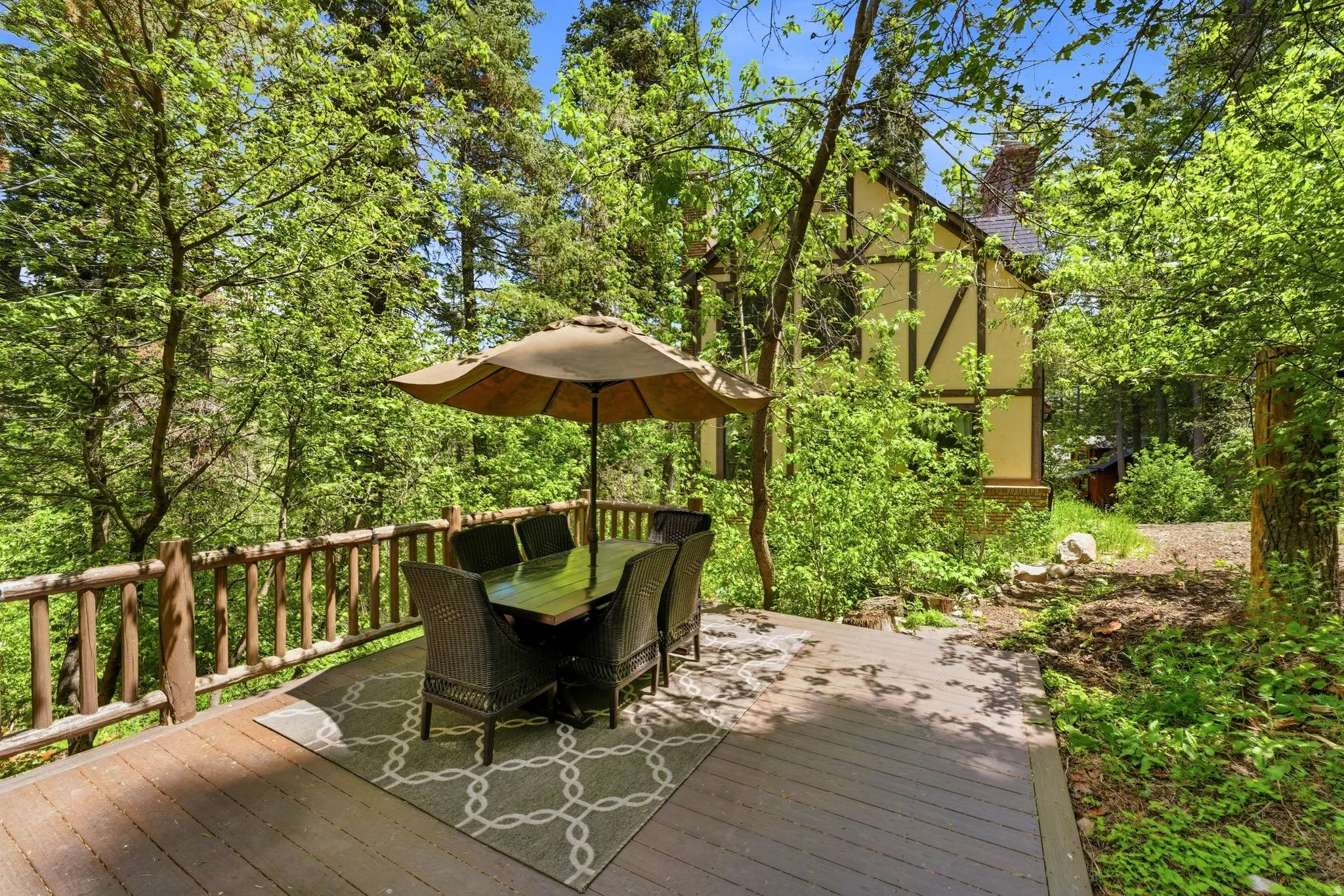 Spacious outdoor deck featuring wood-finish decking and a rustic log railing