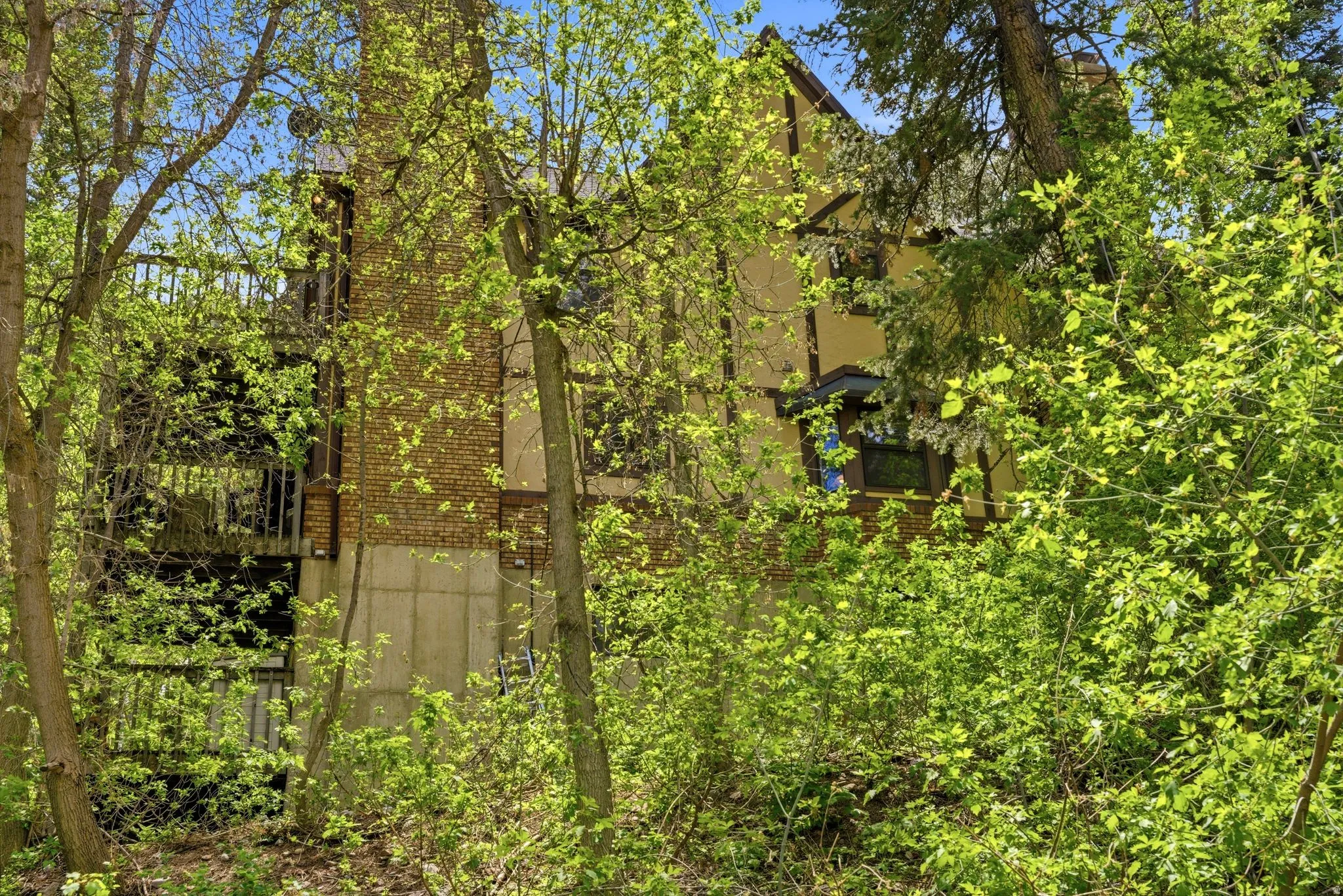 Tudor-style architecture featuring stucco siding, exposed timber framing, and a brick chimney