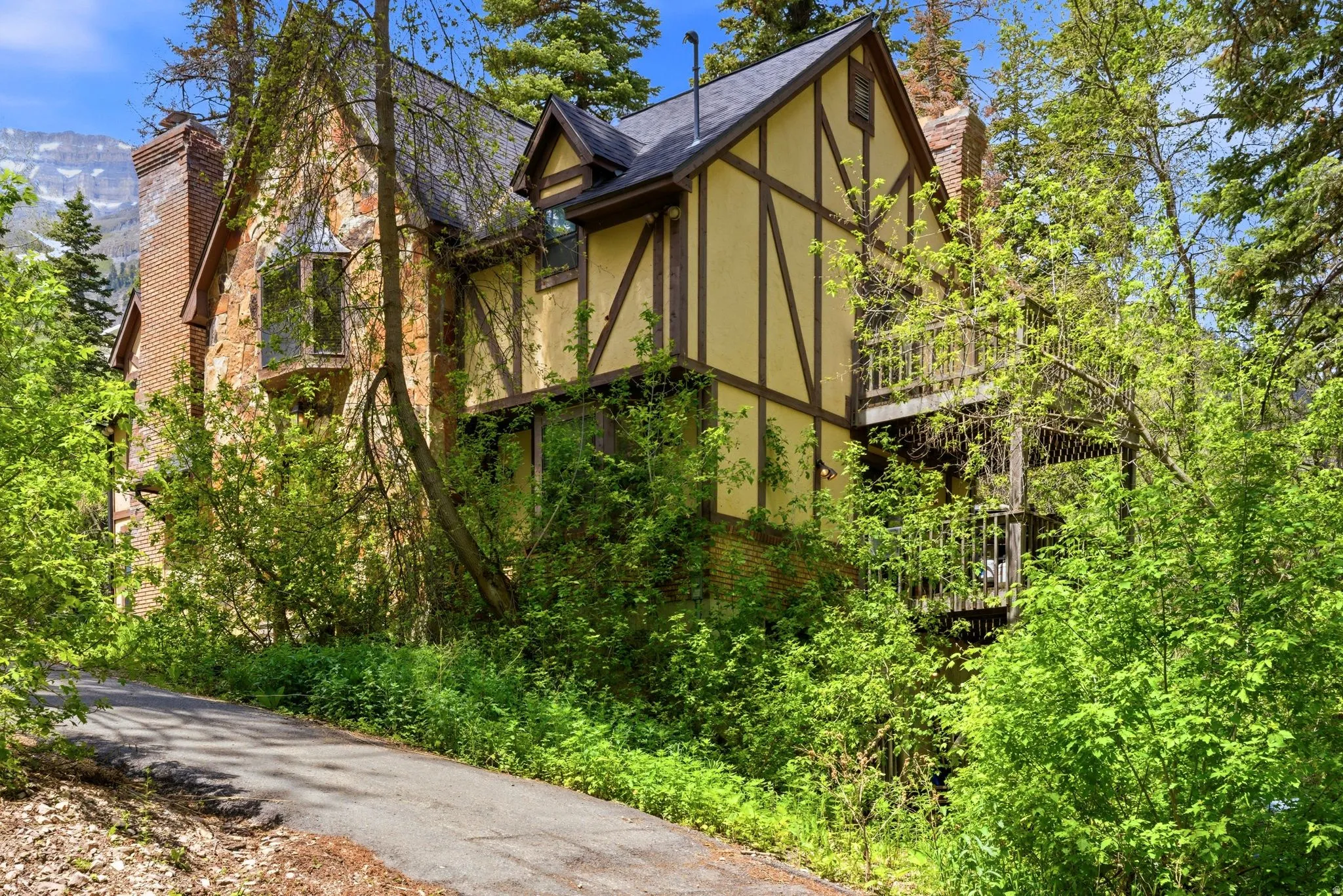 Tudor-style residence featuring stone and stucco siding with timber detailing