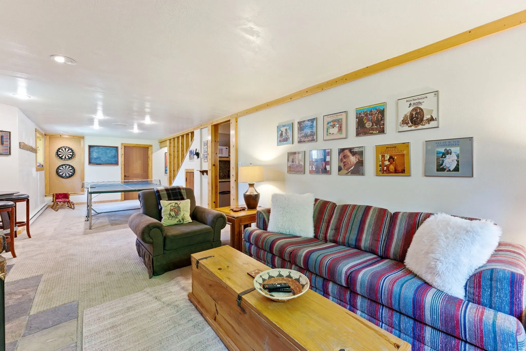 Carpeted recreation room featuring recessed lighting, a built-in wood accent wall, and a wood-finish ceiling beam
