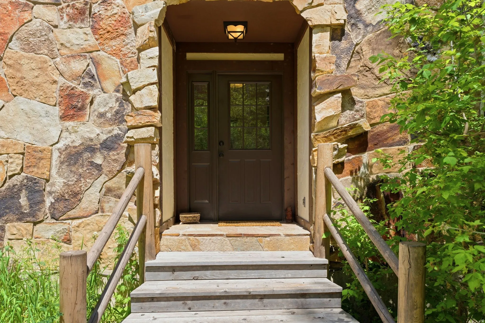 Stone veneer exterior featuring a recessed entry with double doors