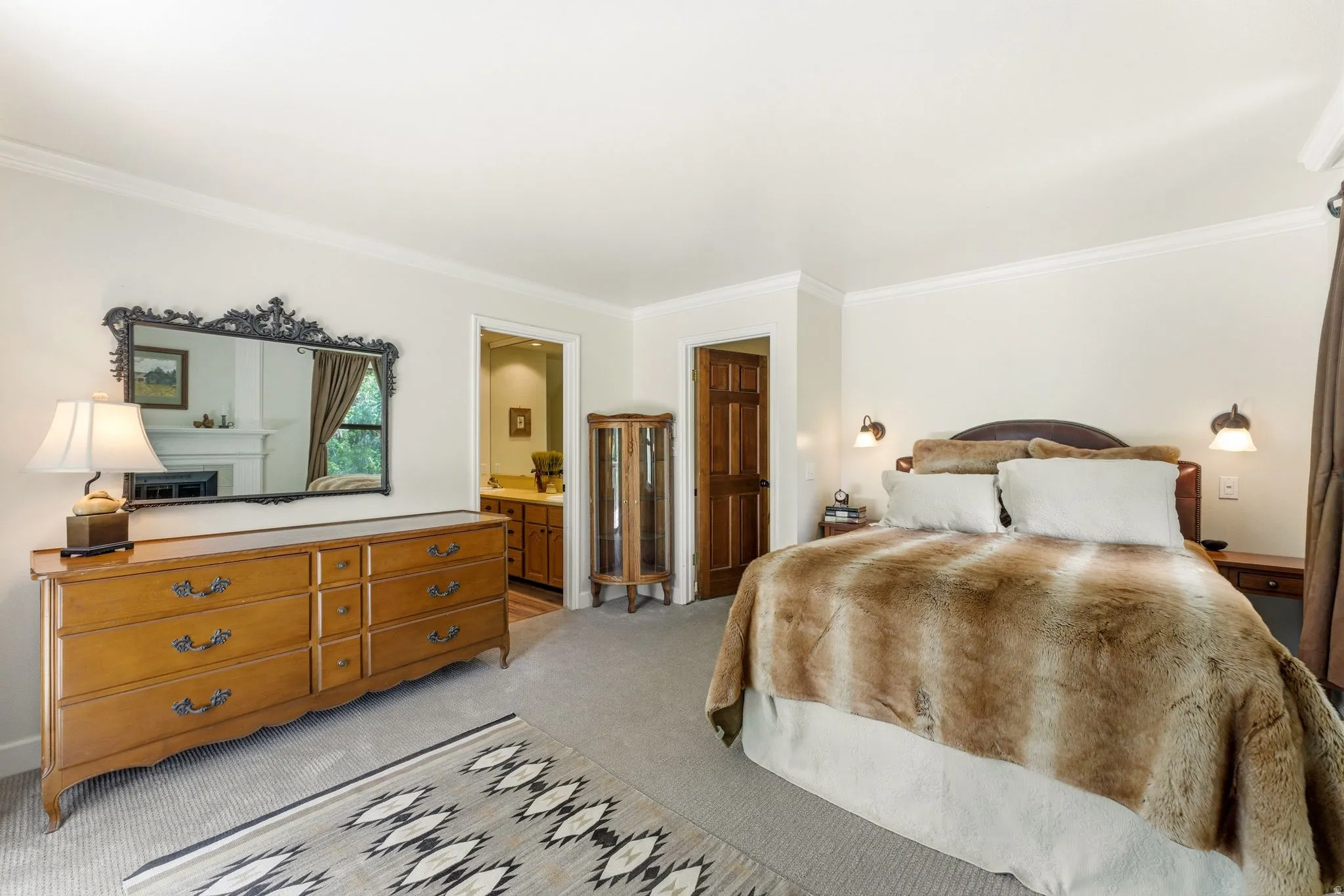 Carpeted bedroom featuring white walls, crown molding, and a solid wood door