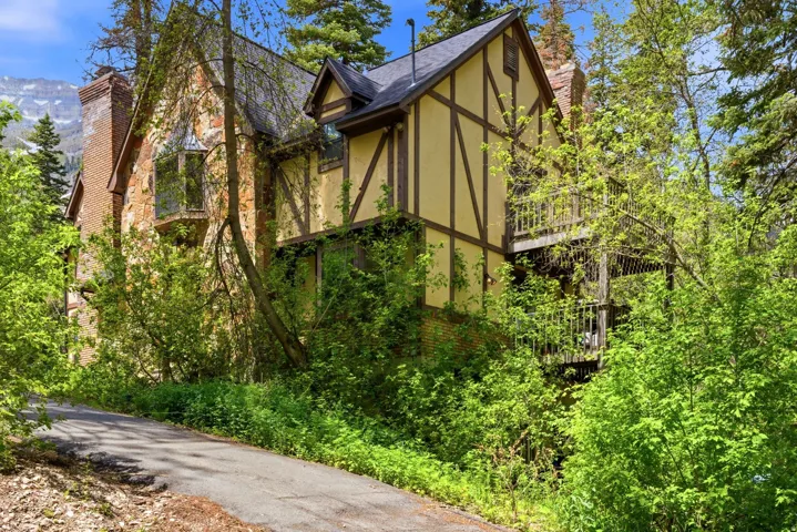 Tudor-style residence featuring stone and stucco siding with timber detailing