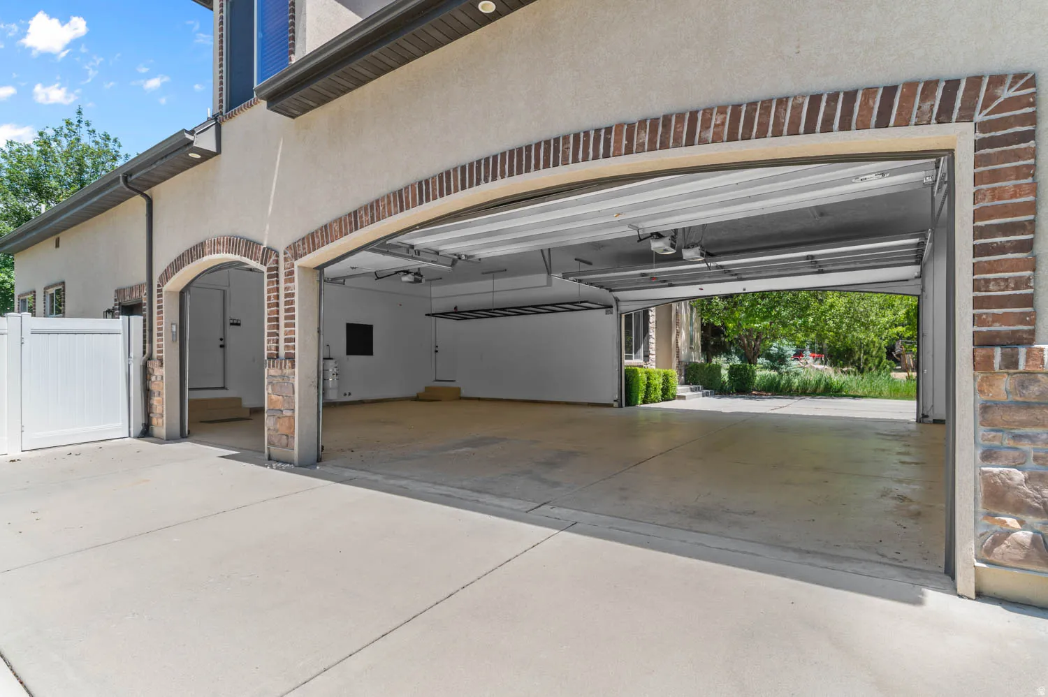 Spacious garage with two bays featuring overhead doors and automatic openers