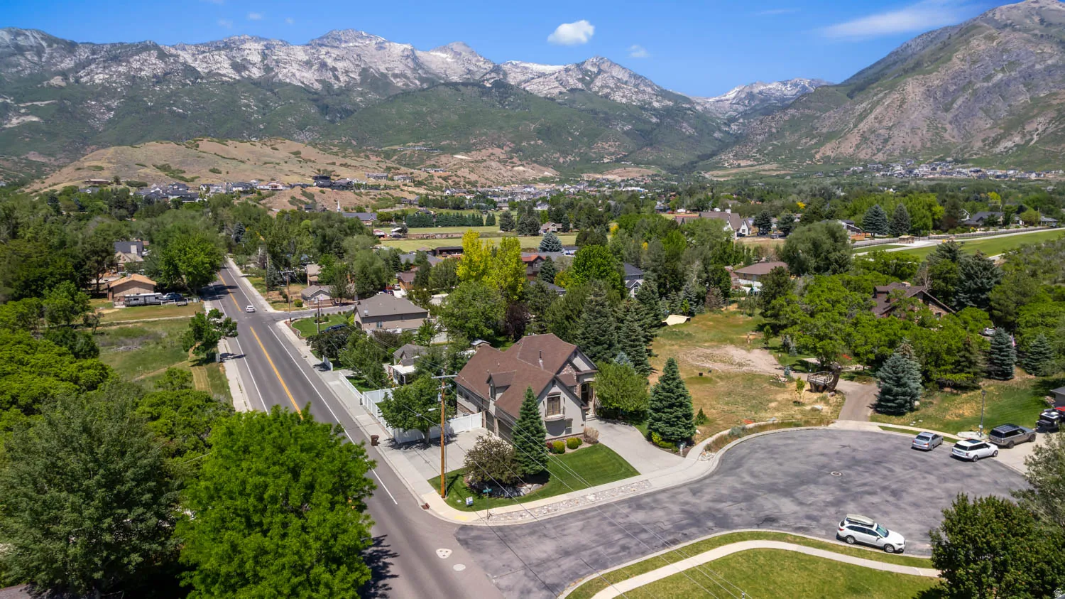 Aerial perspective showcasing a residential property with a multi-car driveway and an attached two-car garage